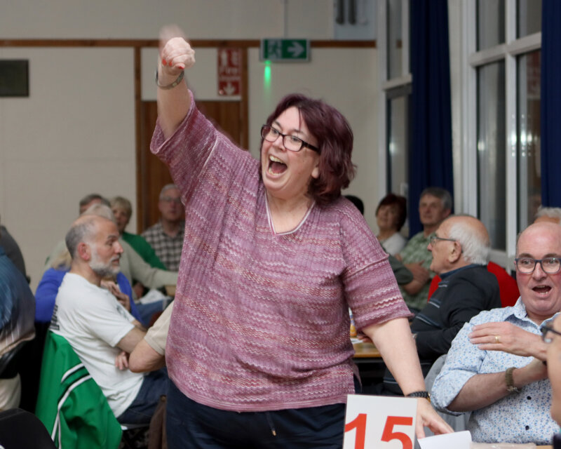 A woman punches the air as she celebrates her team winning the Spring Quiz 2025